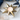 Gold star-shaped candle holder with a lit candle on a white surface.
