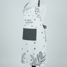 A white kitchen apron with black text reading 'God is nearer to thee than any other living creature' and 'Jesus is the only true God', decorated with black stars and botanical leaf patterns, displayed on a white mannequin torso against a light gray background.