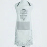 A white bib apron displayed on a mannequin torso against a light gray background. The apron features a dark gray chest pocket, black neck strap, and black printed text on the front reading 'THE DAY IS THE DAY THE LORD HAS MADE we rejoice and be glad'.