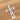 Silver cross pendant on a chain against a wooden background
